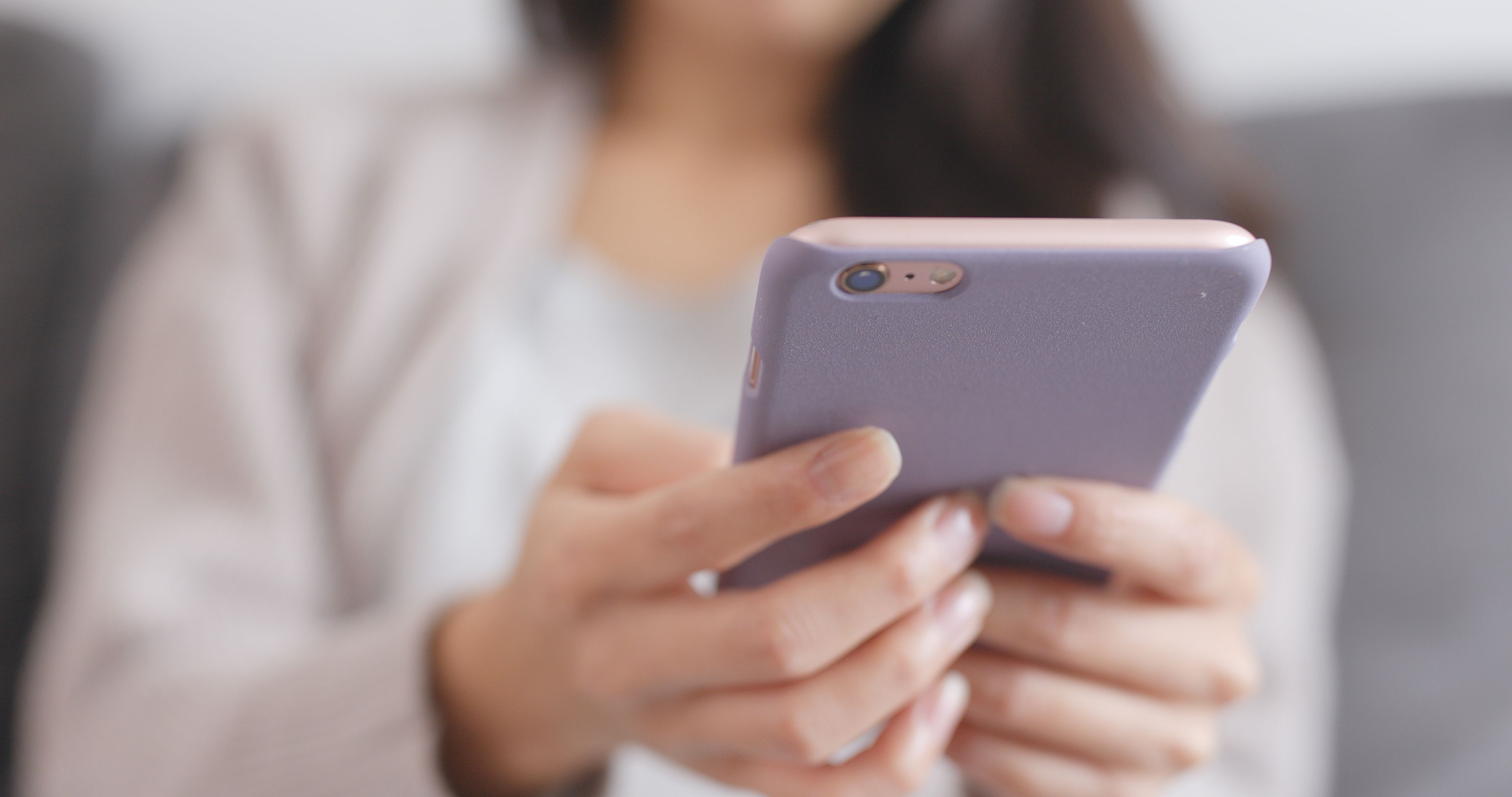 Close-up of hands using the Operate Fit mobile app on a smartphone